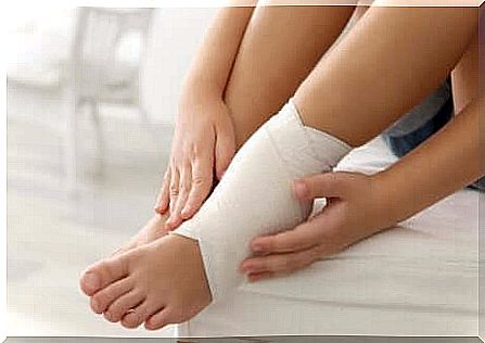 Woman bandaging swollen ankles