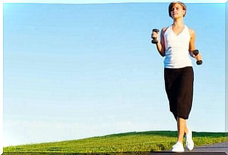 A woman walking with dumbbells. 