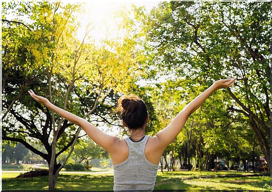 A woman practicing earthing in the middle of nature 