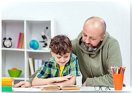 A father helping his son to read. 