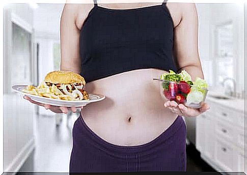 A pregnant woman holding two dishes