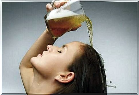 A woman pouring beer on her hair